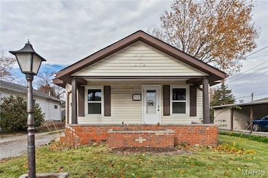 View of front of house featuring covered porch and a front yard