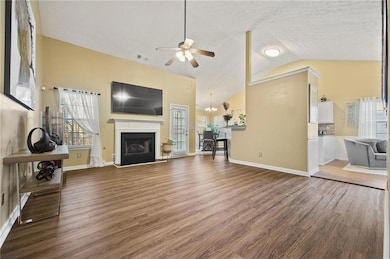 Living room with vaulted ceiling, a fireplace with