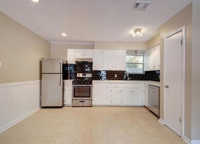 Kitchen with visible vents, a sink, stainless ste