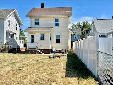 Rear view of property featuring a fenced backyard, a chimney, and a shingled roof