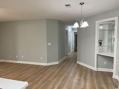 Unfurnished dining area with visible vents, dark w
