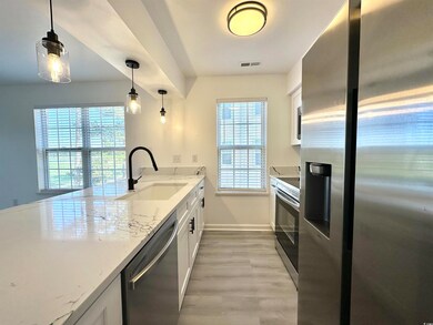 Kitchen featuring appliances with stainless steel finishes, light wood-type flooring, a sink, and a wealth of natural light
