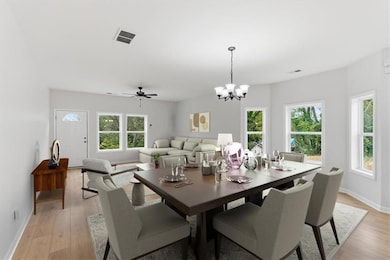 Dining space featuring a chandelier, a ceiling fan, and light wood-style floors