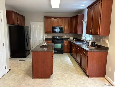 Kitchen with black appliances, dark stone countert