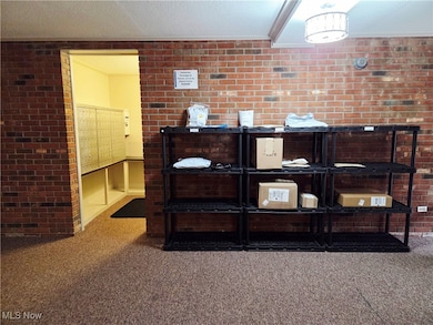 Lobby with brick wall, ornamental molding, mail area, and a textured ceiling