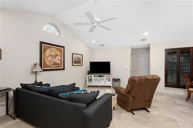 Living area featuring high vaulted ceiling, ceiling fan, and light tile patterned floors