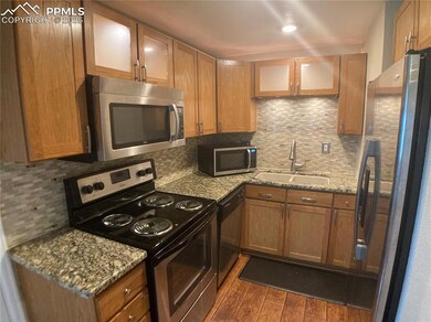 Kitchen with backsplash, stainless steel appliances, dark wood-type flooring, and a sink