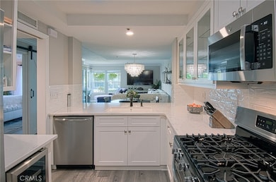Kitchen looking into living area. Kitchen has a wine refrigerator.
