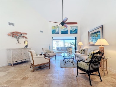 Living room featuring ceiling fan and high vaulted