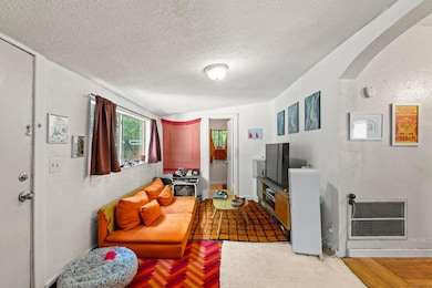 Living room featuring a textured ceiling, wood fi