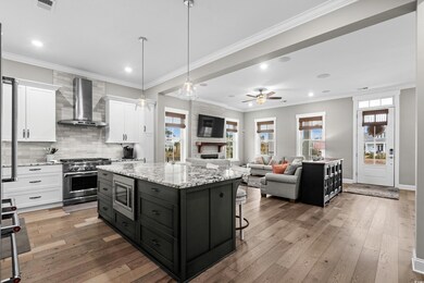 Kitchen featuring wall chimney range hood, light h