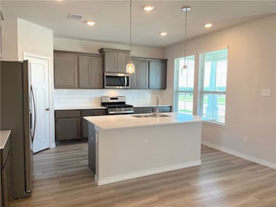 Kitchen with stainless steel appliances, a sink, l