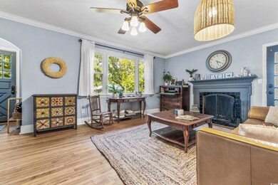 Living room with ornamental molding, light hardwoo
