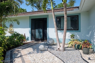 View of exterior entry with roof with shingles and