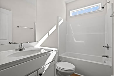 Full bathroom with toilet, vanity, and bathing tub