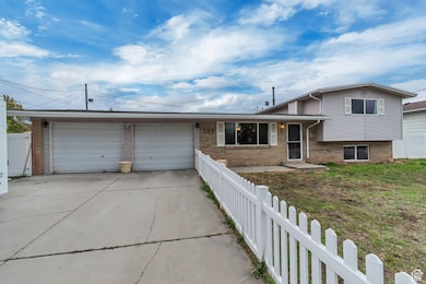 Split level home with brick siding, concrete driveway, and a garage