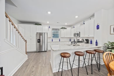 Kitchen featuring sink, white cabinetry, appliance