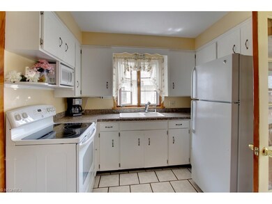 This lovely kitchen with tile floors offers white 