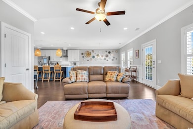Living room with ornamental molding, dark wood-sty