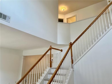 Stairway featuring a towering ceiling