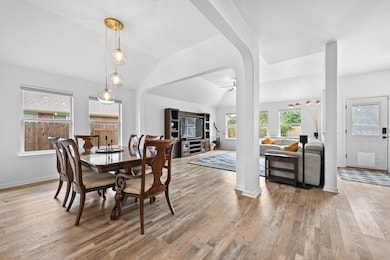 Dining area with lofted ceiling, plenty of natural light, light wood finished floors, and a ceiling fan