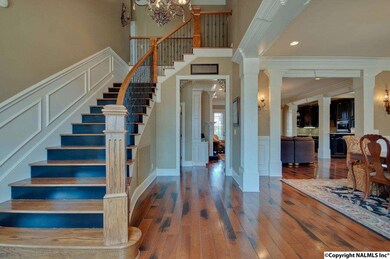 THIS GRACIOUS FOYER WELCOMES FRIENDS AND FAMILY IN STYLE WITH ITS BEAUTIFUL HARDWOOD FLOORS, WROUGHT IRON ACCENTS AND SOARING CEILING.