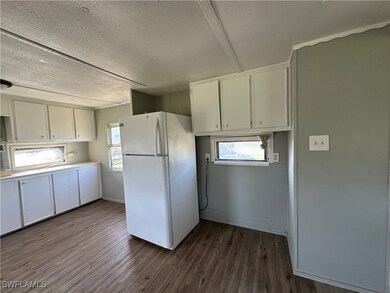 Kitchen featuring freestanding refrigerator, white
