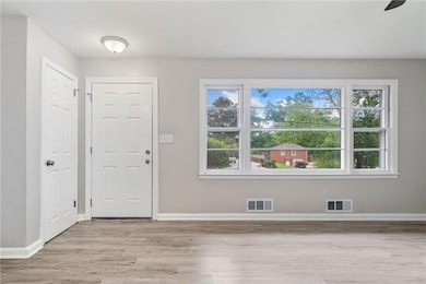 Foyer entrance with light wood finished floors and baseboards