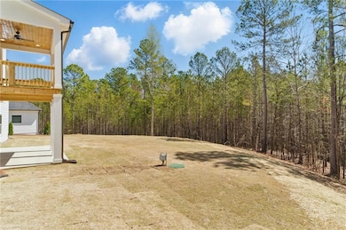 View of yard with a ceiling fan and a wooded view
