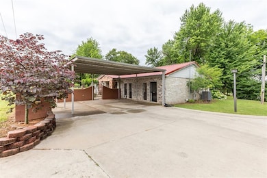 View of front of property featuring driveway, central AC unit, and a front lawn