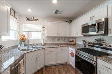 Kitchen with stainless steel appliances, a sink, w