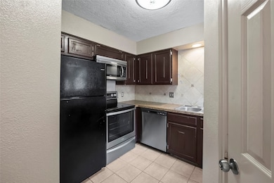 Cozy kitchen featuring dark wood cabinets, granite