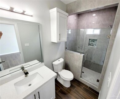 Bathroom featuring vanity, toilet, and a shower with shower door