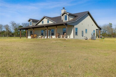 Rear view of house with a yard, central AC unit, a
