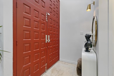 Foyer entrance featuring baseboards and light tile