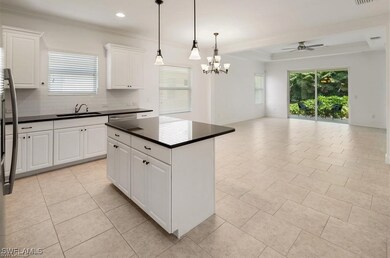 Kitchen with ceiling fan, dark countertops, open f
