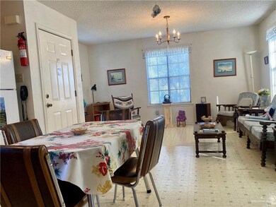 Dining area featuring an inviting chandelier, a textured ceiling, and light tile floors