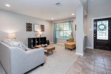 Carpeted living room with recessed lighting and baseboards