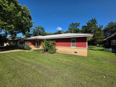 View of front facade featuring a front yard, crawl space, an attached garage, and a metal roof