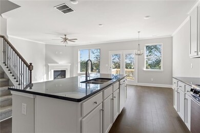 Kitchen featuring a sink, ceiling fan, a fireplace, plenty of natural light, and ornamental molding