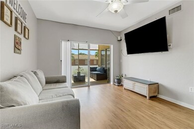 Living room featuring ceiling fan, light wood-styl