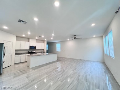 Kitchen with a center island with sink, stainless