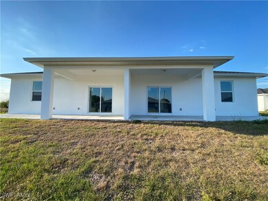 Rear view of house featuring stucco siding and a l