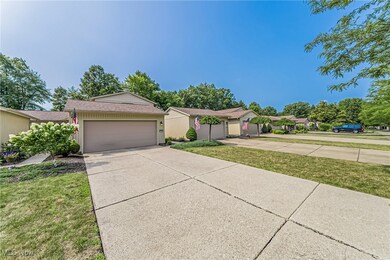Single story home with a garage and a front lawn