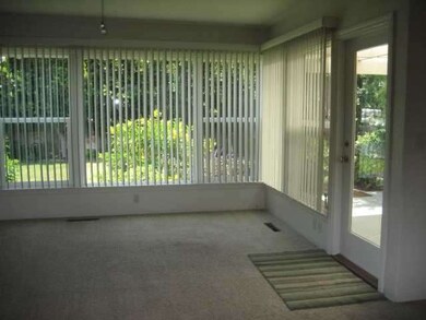 Large windows, neutral carpet over hardwood floors