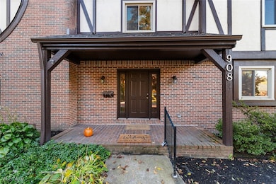 View of exterior entry with a porch, brick siding, and stucco siding