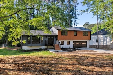 Tri-level home with an attached garage, fence, and