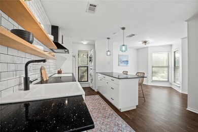 Kitchen with a kitchen breakfast bar, open shelves, tasteful backsplash, decorative light fixtures, and dark wood-style floors