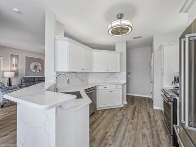 Kitchen featuring white cabinetry, a sink, stainle