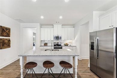 Kitchen with dark wood-type flooring, stainless st